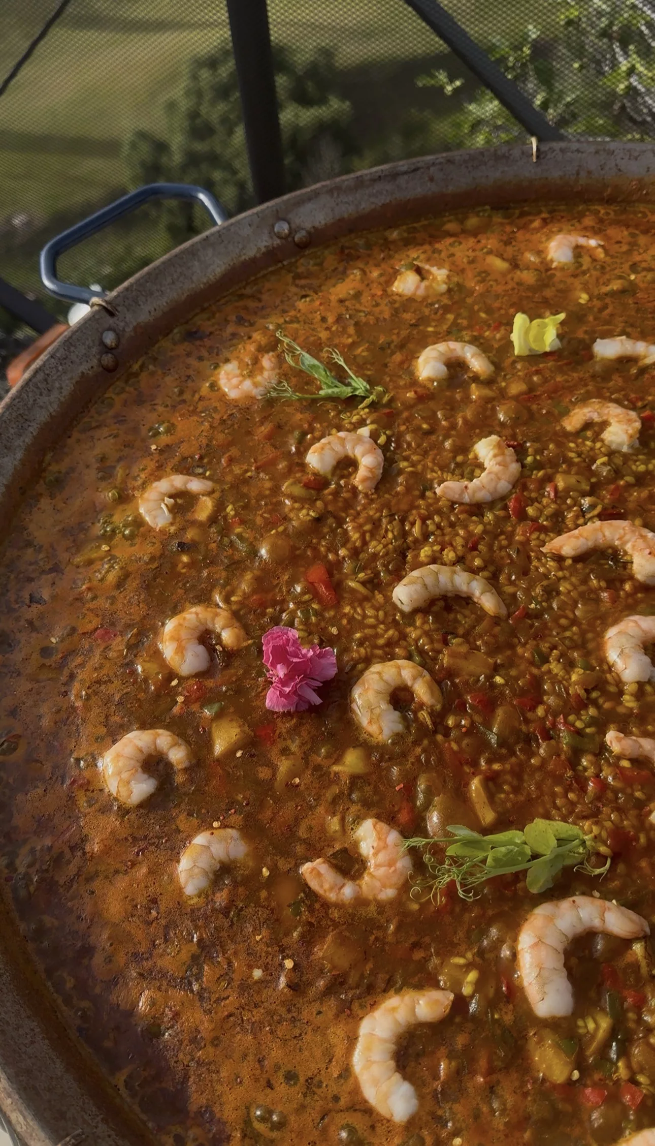 Fresh seafood paella served with salads and aioli at outdoor dinner party in Marbella