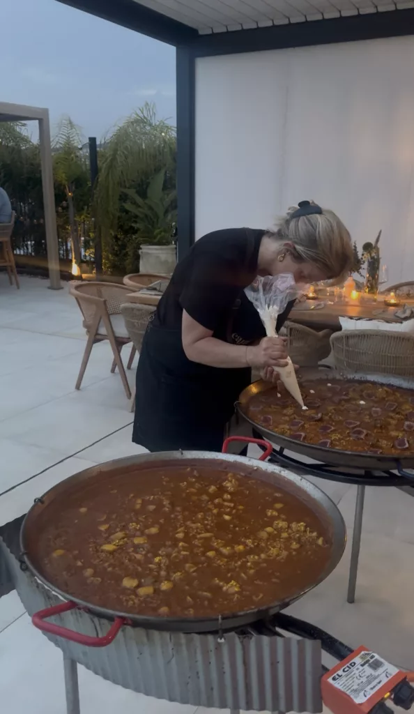 Traditional paella being cooked in large pan at private villa event in Marbella by Campo Catering chef