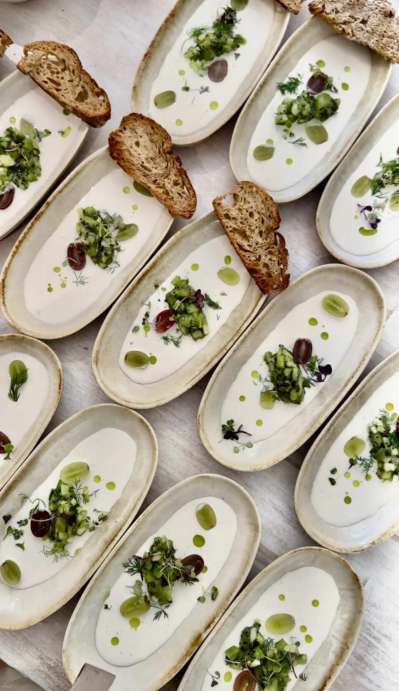 Individual cold soup starters with herb oil, cucumber salsa and microgreens served at a private dinner in Marbella by Campo
