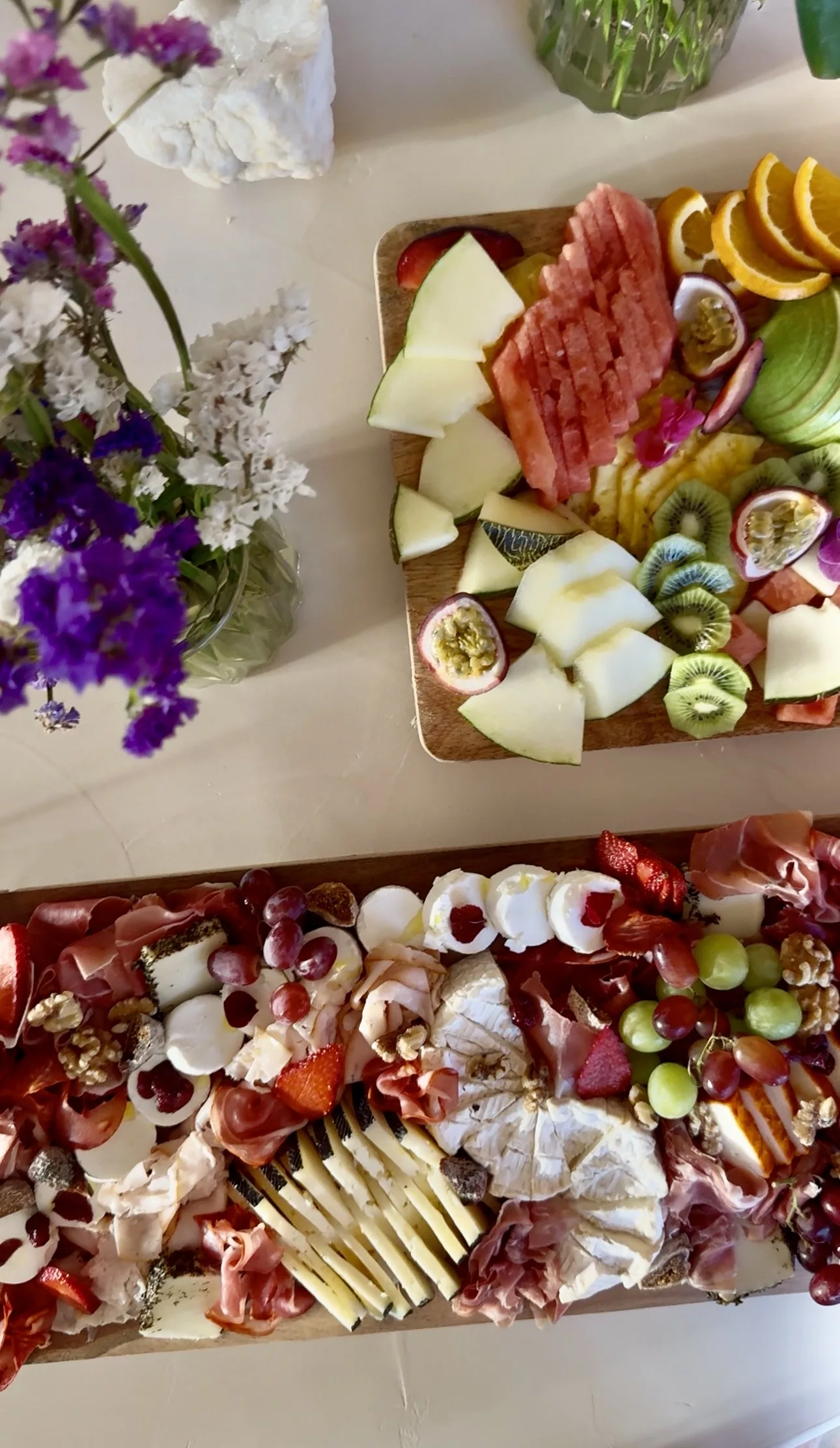 Grazing table with charcuterie board, Brie, prosciutto, grapes and tropical fruit platter at a Marbella catering event by Campo