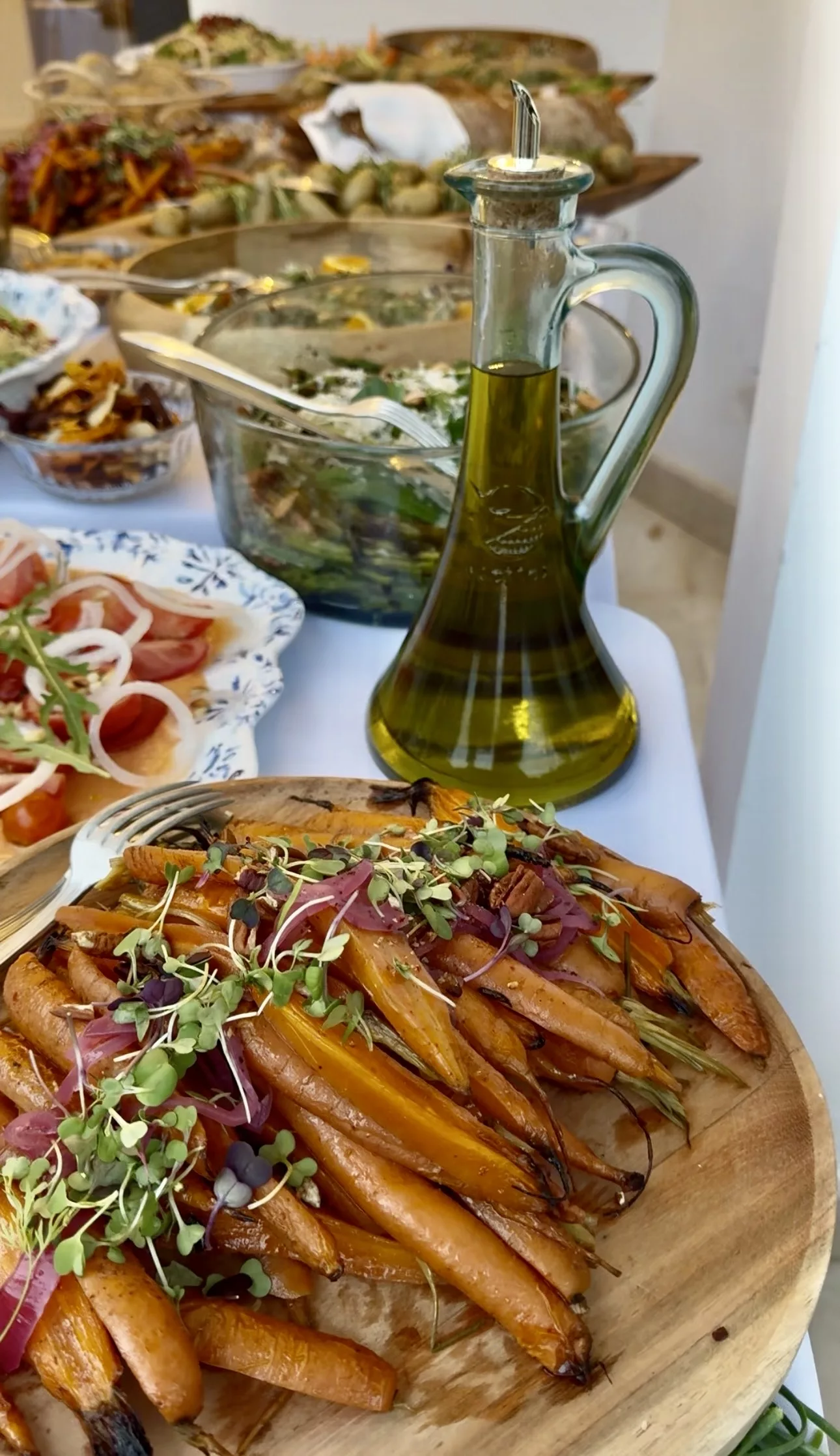 Roasted carrots with microgreens on a wooden board, seasonal salads at a Campo Marbella BBQ wedding