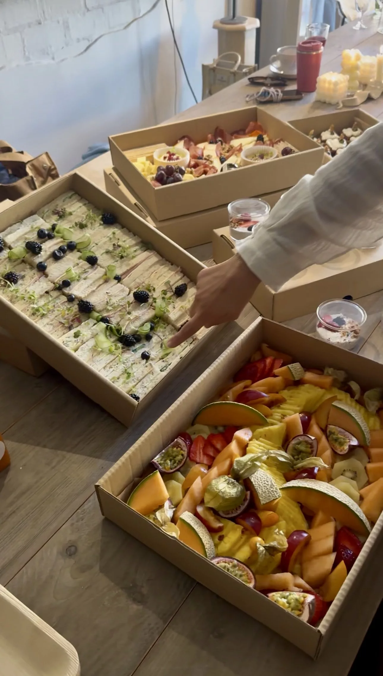 Sauge platter table with sandwich, fruit and charcuterie boxes for a Marbella office event